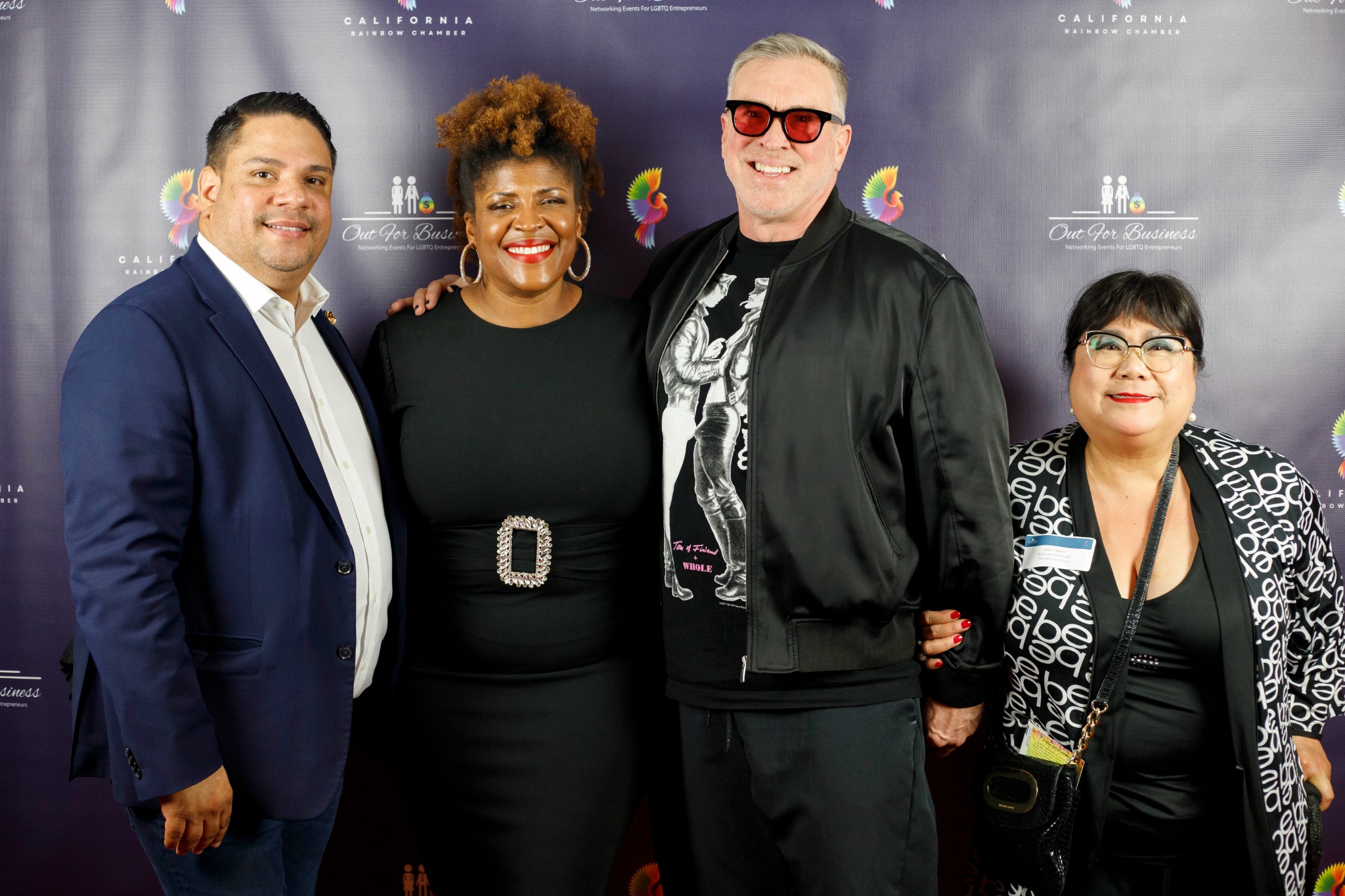 Four guests together in front of a California Rainbow Chamber backdrop